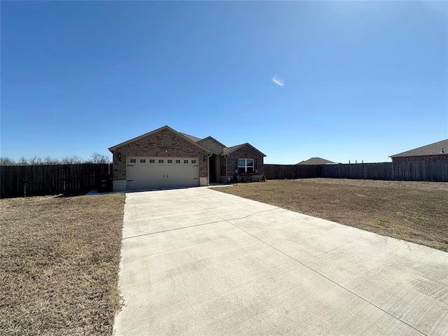 view of front of property featuring a garage, brick siding, concrete driveway, and fence