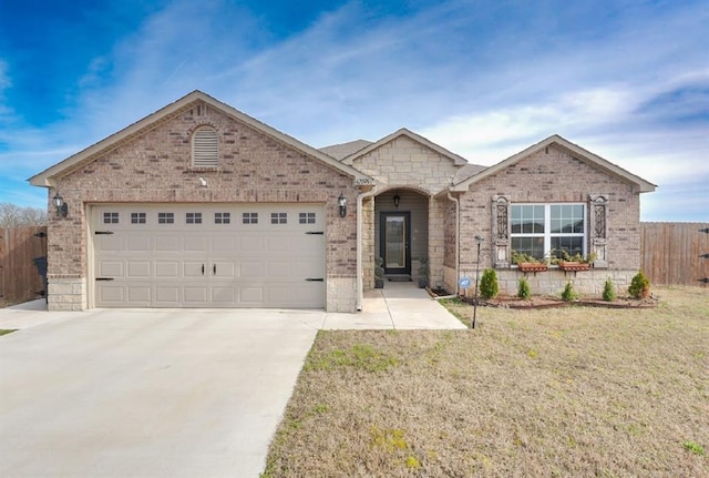 view of front facade with brick siding, fence, concrete driveway, a front yard, and a garage