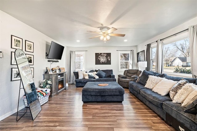 living room featuring ceiling fan, baseboards, recessed lighting, wood finished floors, and a glass covered fireplace