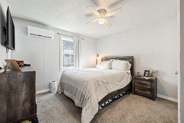 carpeted bedroom with a textured ceiling, a wall unit AC, baseboards, and ceiling fan