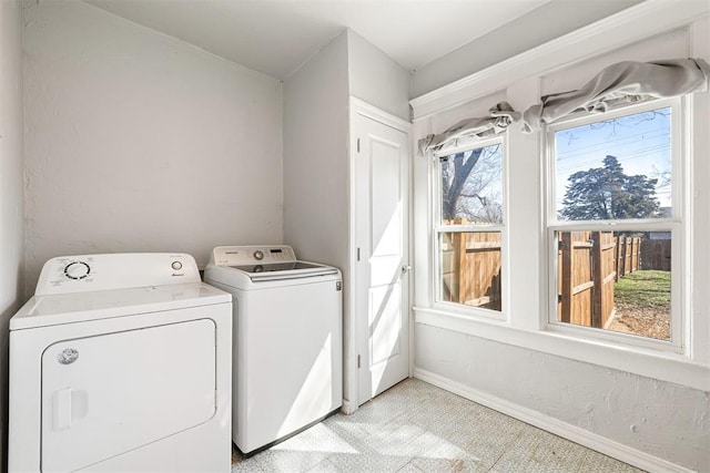 laundry room with laundry area, separate washer and dryer, baseboards, and light floors