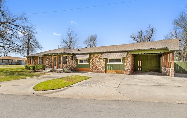 view of front of home featuring brick siding, an attached carport, and driveway