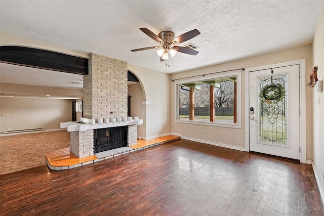 unfurnished living room with visible vents, a textured ceiling, wood-type flooring, a fireplace, and ceiling fan