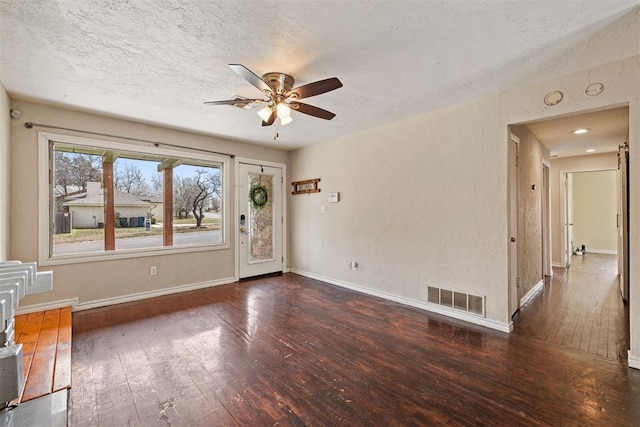 interior space featuring visible vents, baseboards, ceiling fan, and hardwood / wood-style floors