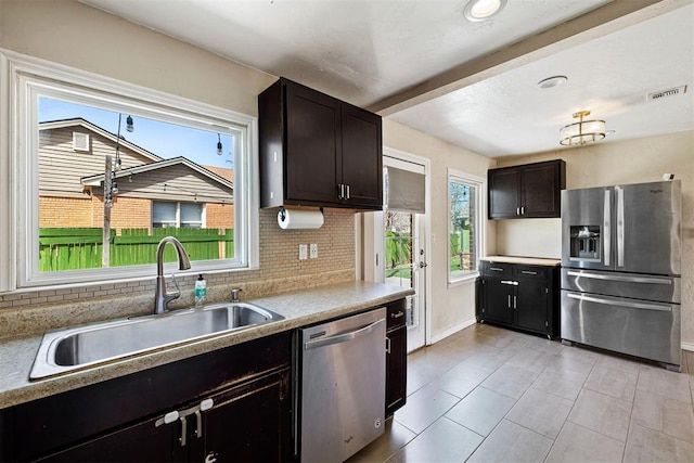 kitchen featuring tasteful backsplash, visible vents, appliances with stainless steel finishes, plenty of natural light, and a sink