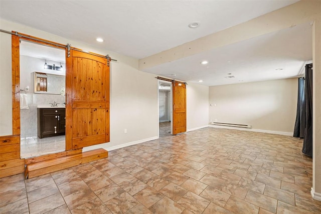 interior space featuring baseboards, a barn door, baseboard heating, recessed lighting, and a sink