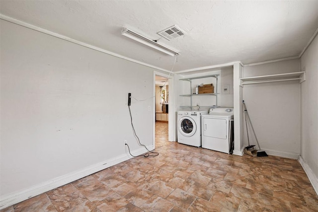 clothes washing area with baseboards, visible vents, laundry area, a textured ceiling, and washer and dryer