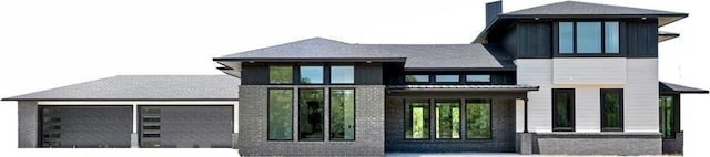 back of house with brick siding, concrete driveway, and an attached garage