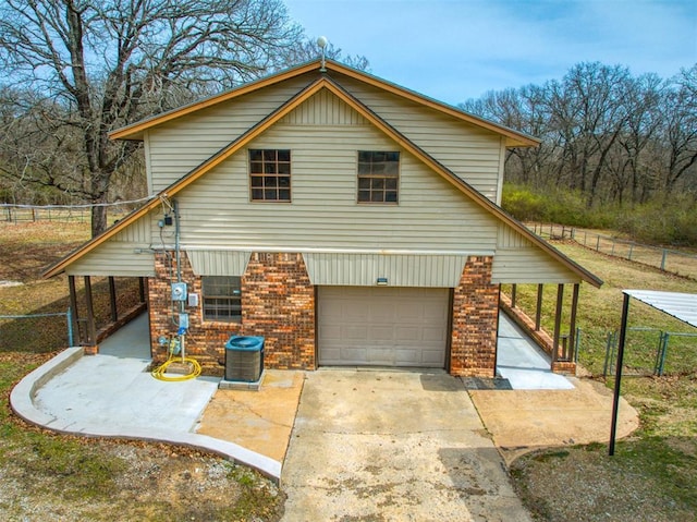 view of property exterior with brick siding, concrete driveway, a garage, and fence