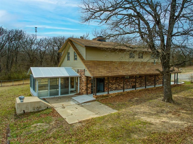 back of property featuring a patio area, a sunroom, brick siding, and fence