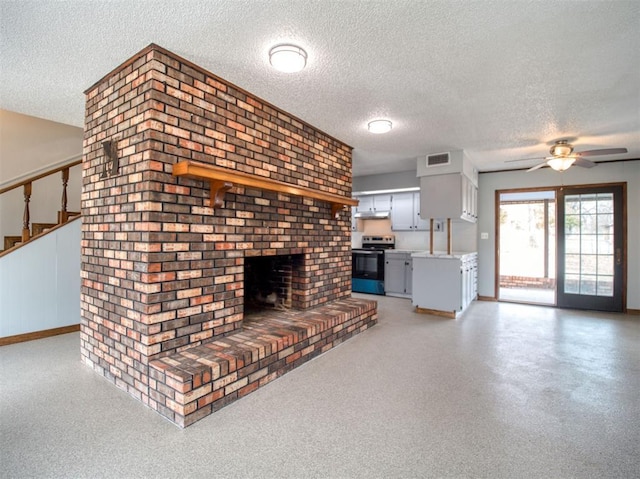 unfurnished living room with visible vents, a textured ceiling, ceiling fan, and a fireplace