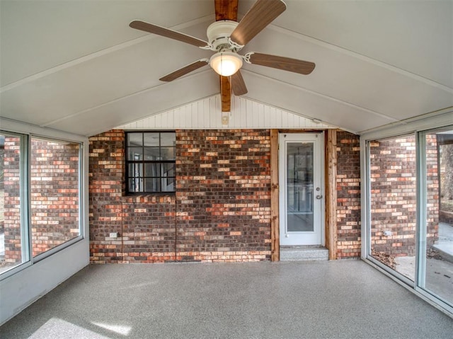 unfurnished sunroom with a healthy amount of sunlight, a ceiling fan, and vaulted ceiling