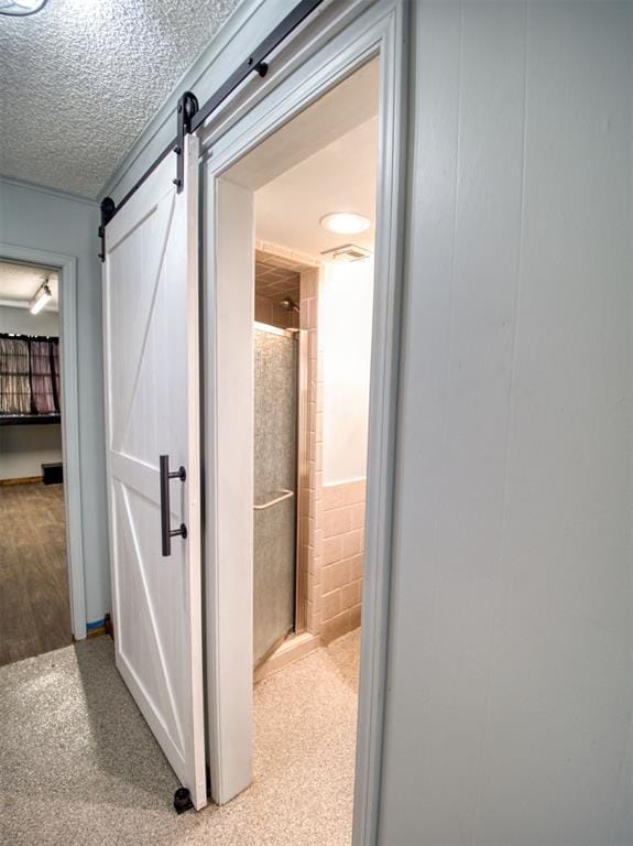 hallway featuring a textured ceiling and a barn door