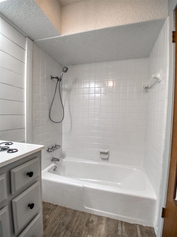 bathroom featuring vanity, wood finished floors, and shower / washtub combination