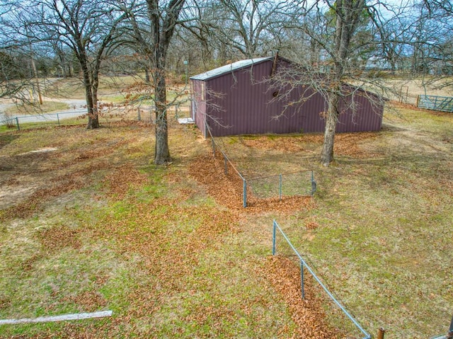 view of yard with fence, an outdoor structure, and a pole building