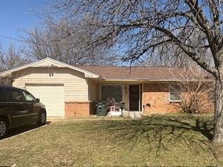 single story home with a garage and a front lawn