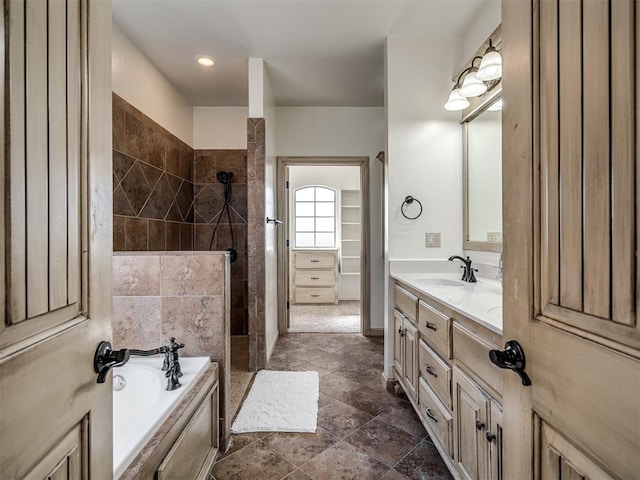 bathroom featuring a garden tub, walk in shower, and vanity