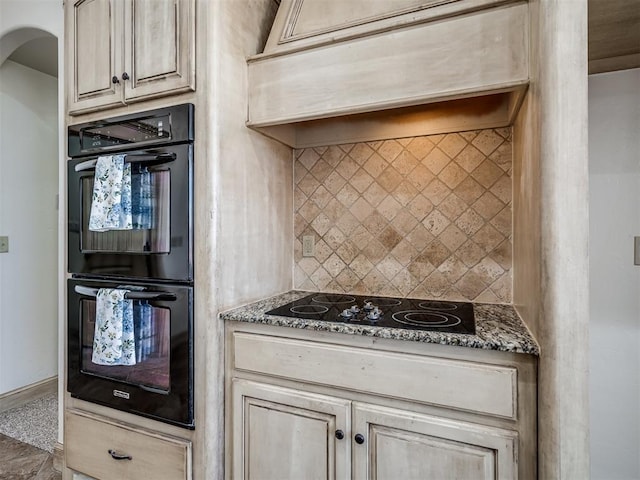 kitchen featuring baseboards, premium range hood, decorative backsplash, arched walkways, and black appliances