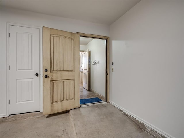 interior space with unfinished concrete flooring and baseboards