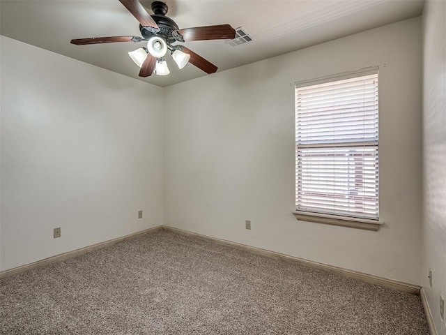 unfurnished room with baseboards, visible vents, carpet floors, and ceiling fan