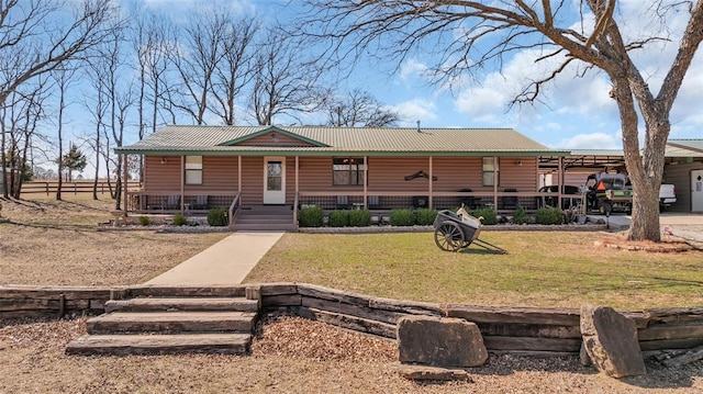 view of front of house featuring faux log siding, a front yard, covered porch, and metal roof