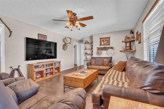 living area with wood finished floors, a textured ceiling, and ceiling fan