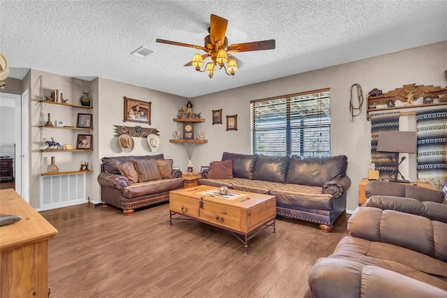 living area with ceiling fan, visible vents, a textured ceiling, and wood finished floors