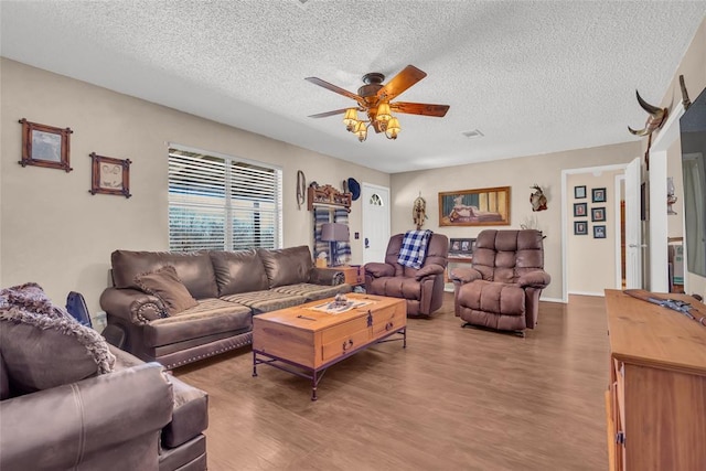 living room featuring a textured ceiling, ceiling fan, and wood finished floors