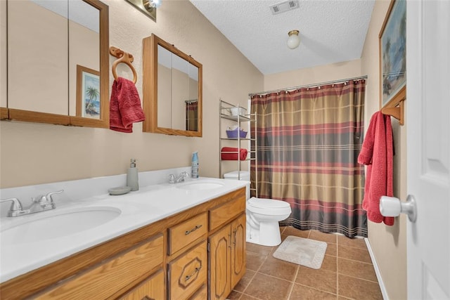 bathroom featuring a sink, visible vents, toilet, and tile patterned floors