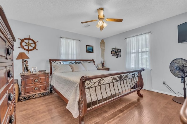 bedroom featuring a textured ceiling, ceiling fan, and wood finished floors