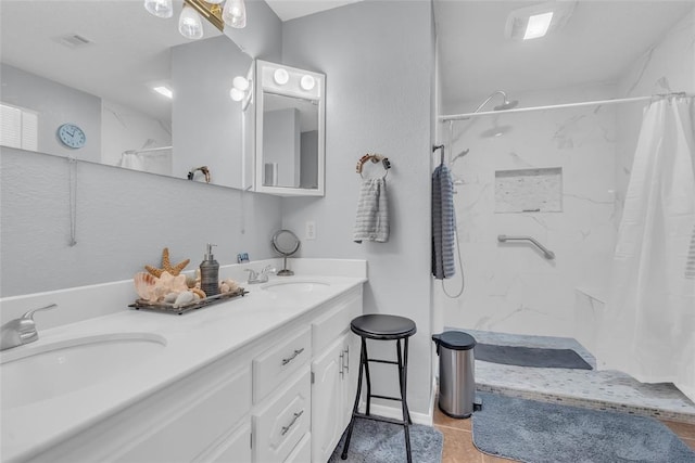 full bathroom with a marble finish shower, double vanity, and a sink