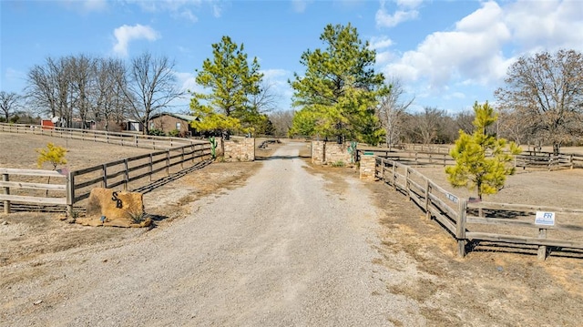 view of road featuring a gate, a rural view, driveway, and a gated entry