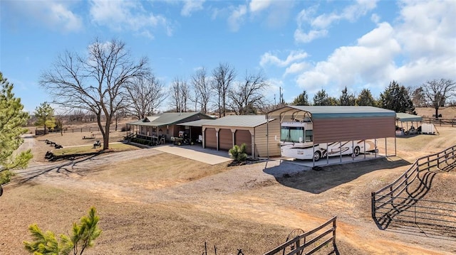 view of front of house featuring an outdoor structure, fence, and driveway