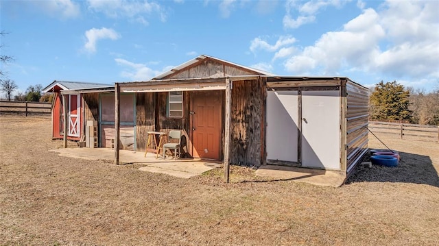 view of outbuilding featuring an outdoor structure and fence