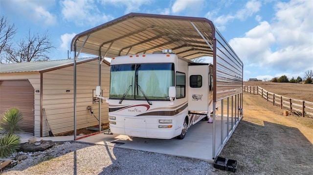 view of parking with a carport and fence