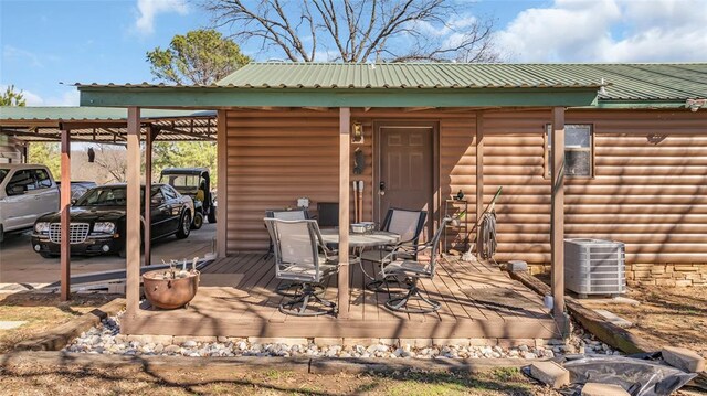 exterior space featuring a carport, central AC, and outdoor dining space