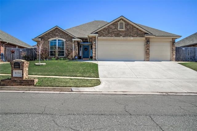 view of front facade with a garage, brick siding, a front lawn, and fence