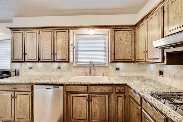 kitchen featuring under cabinet range hood, backsplash, appliances with stainless steel finishes, and a sink