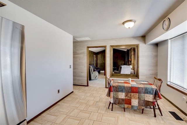 dining room with baseboards, visible vents, and a textured ceiling