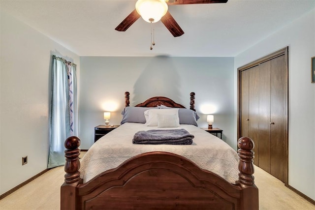 bedroom with a closet, baseboards, light colored carpet, and ceiling fan