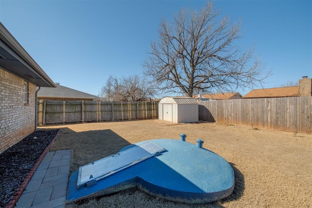 view of yard featuring a storage shed, an outdoor structure, and a fenced backyard