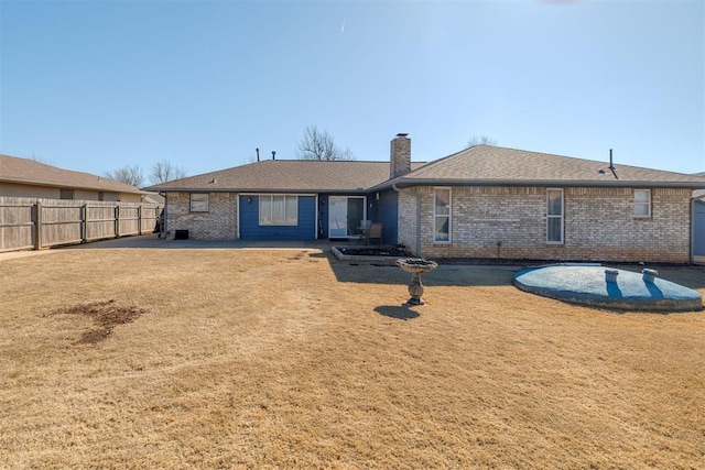 rear view of property with a patio area, brick siding, a chimney, and fence