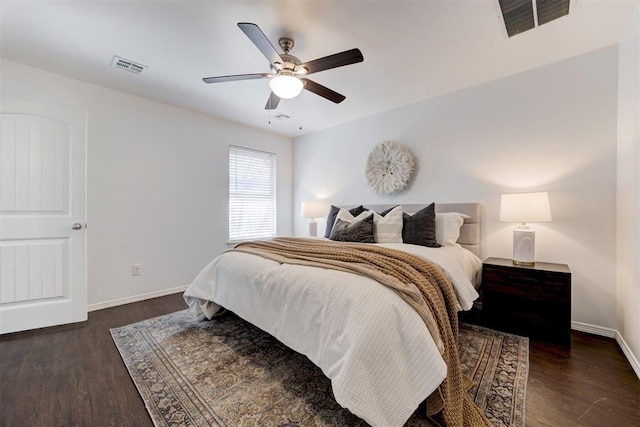 bedroom with wood finished floors, visible vents, and baseboards