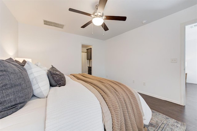 bedroom with visible vents, baseboards, wood finished floors, and a ceiling fan