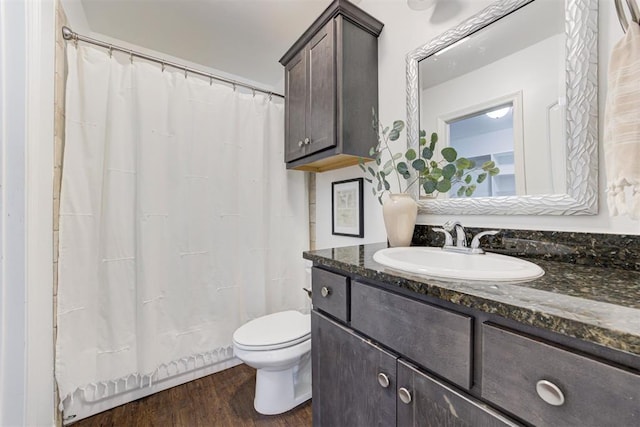 bathroom with toilet, vanity, a shower with curtain, and wood finished floors