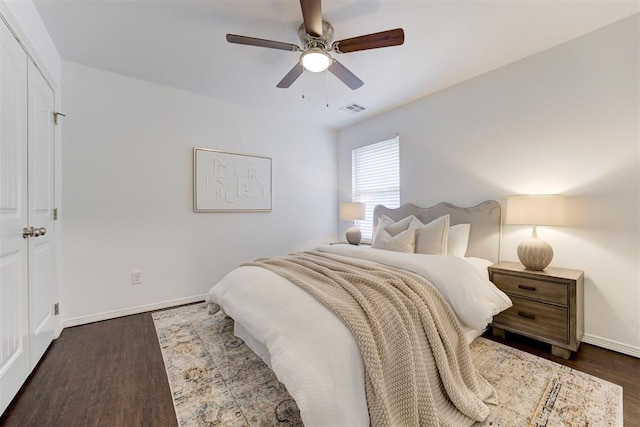 bedroom featuring visible vents, baseboards, a ceiling fan, and dark wood-style flooring