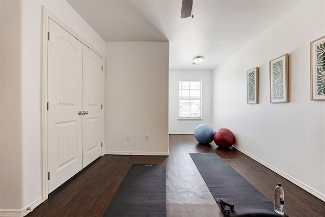 exercise area featuring baseboards and dark wood-style flooring