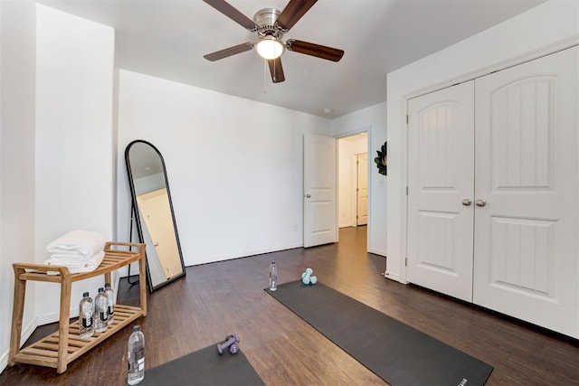 workout area featuring ceiling fan, baseboards, and wood finished floors