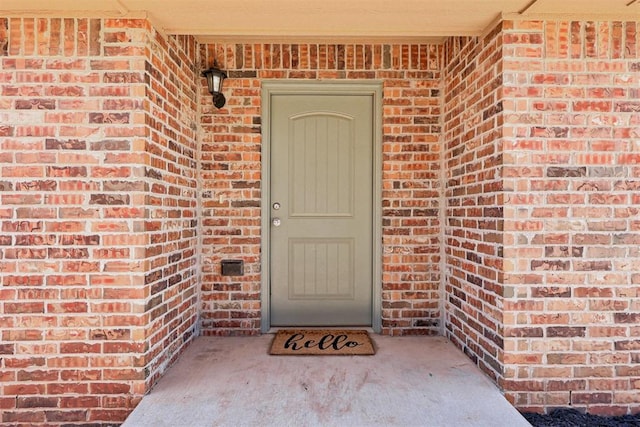 doorway to property featuring brick siding