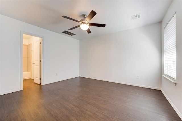 unfurnished room featuring visible vents, baseboards, and dark wood-type flooring